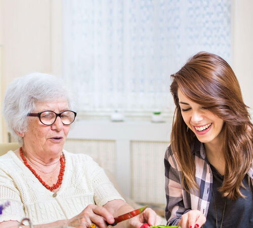 Seniorin mit junger Frau beim Kochen